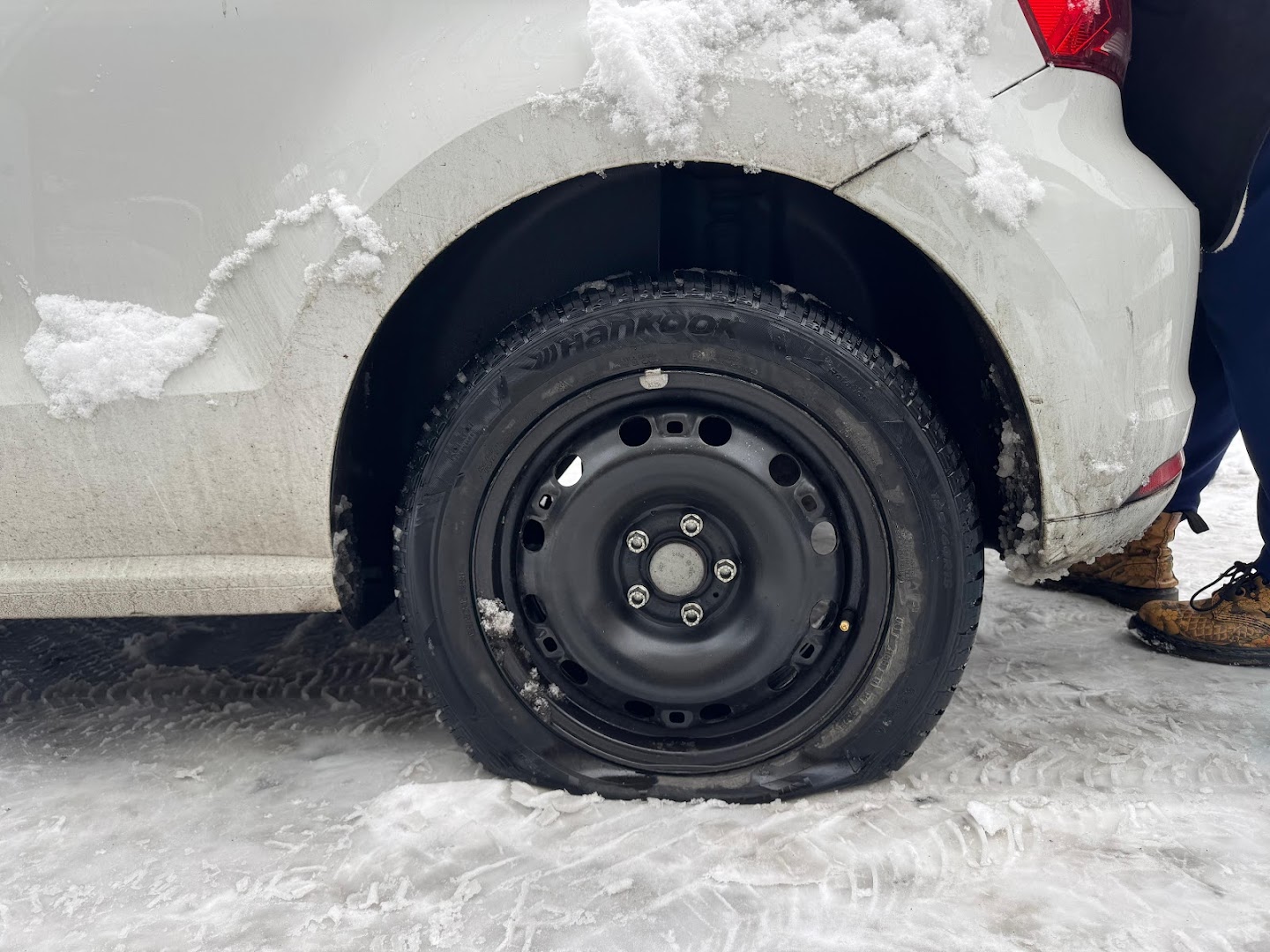 Winterpneu Hankook auf Stahlfelge an einem Auto im Schnee — Reifenwechsel bei der Veskovac Garage in Luzern